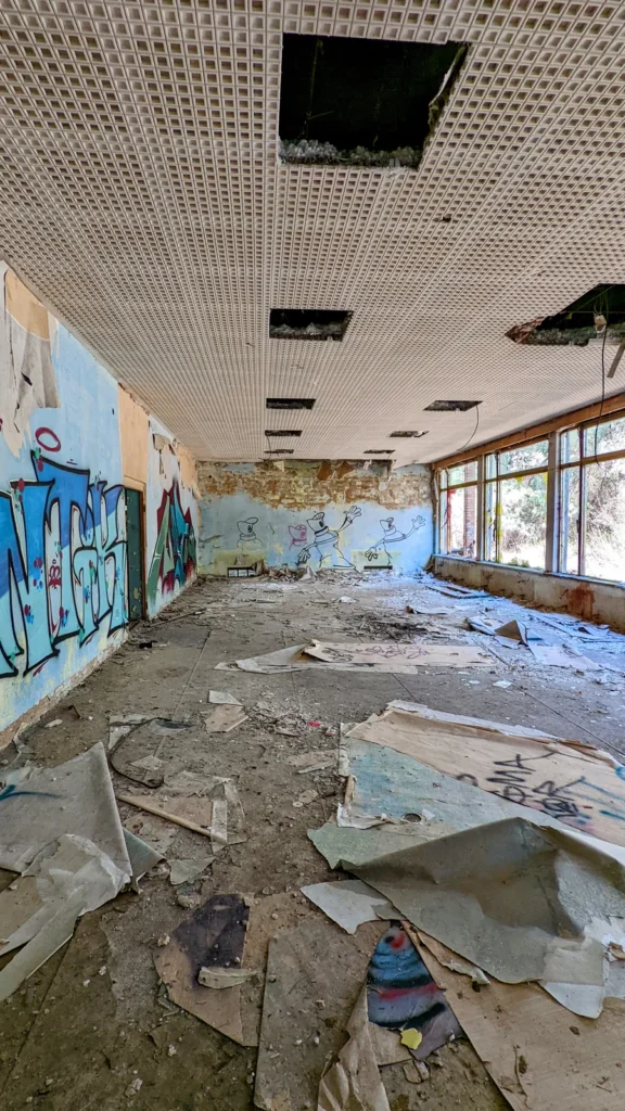 Weiter Raum mit Lochdecke, Graffiti an der linken Wand und Fensterband