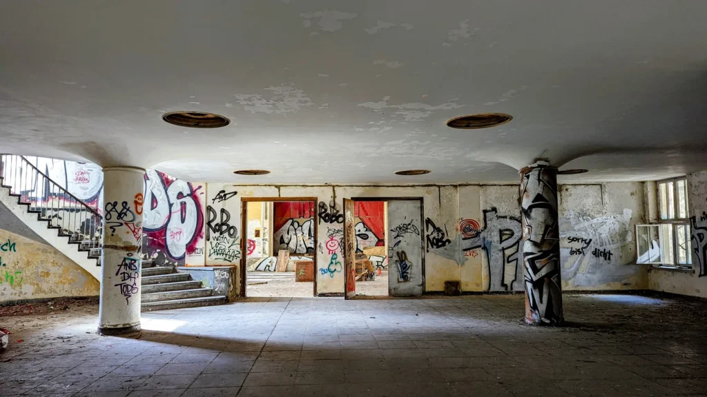 Großer Saal mit Säulen und Treppe, Graffiti an den Wänden