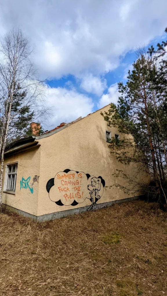 Gelbes Gebäude mit Sprechblase und schwarzer Tierfigur an der Wand