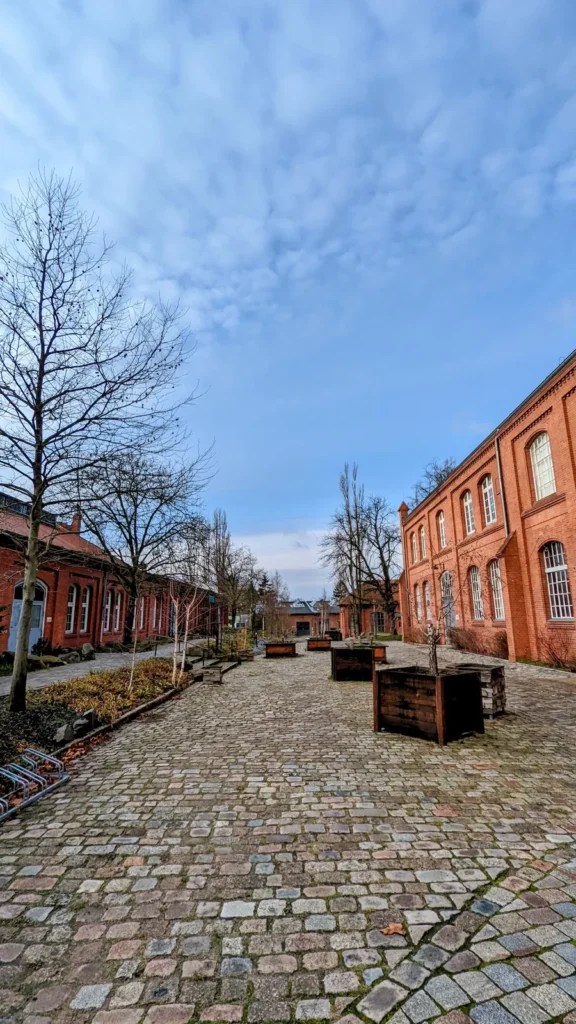 Gepflasterter Hof mit Backsteinhallen im ehemaligen Gaswerk Mariendorf