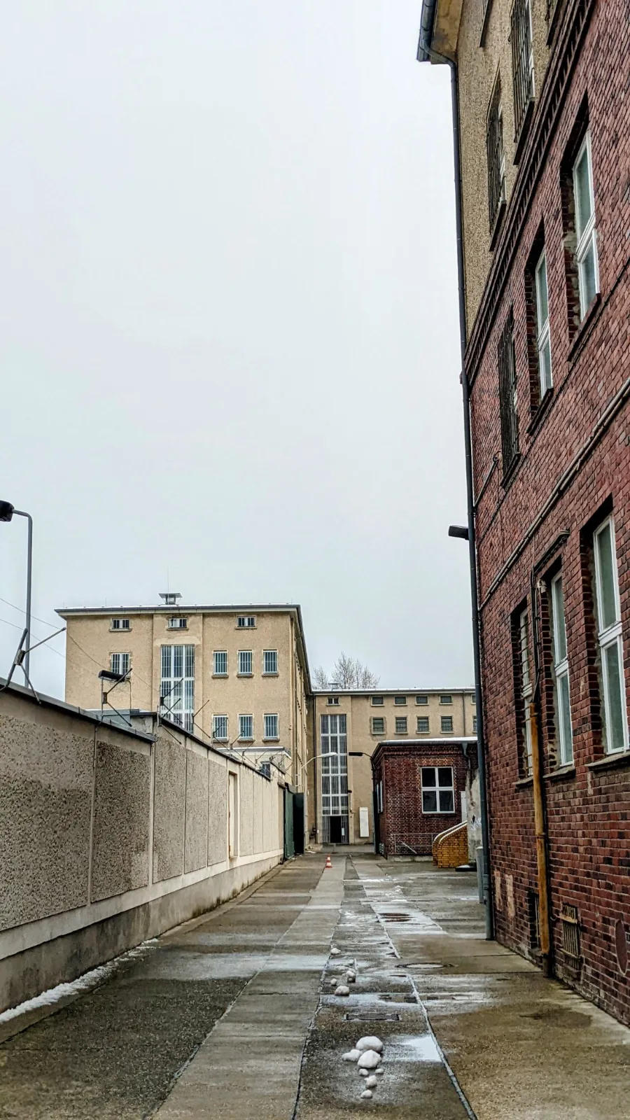 Schmale Gasse zwischen einer Mauer und einem Backsteinbau an der Gedenkstätte Hohenschönhausen