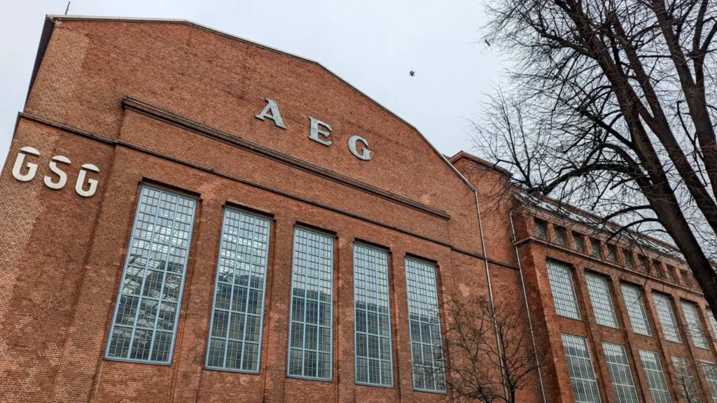 Backsteinfabrik mit großen Sprossenfenstern und AEG-Schriftzug am Giebel an der Hussitenstraße