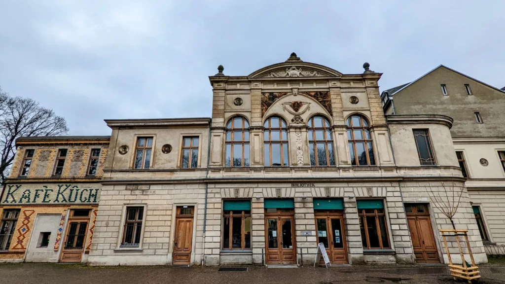 Historischer Bau der Bibliothek am Luisenbad mit Rundbogenfenstern und Giebelschmuck an der Badstraße