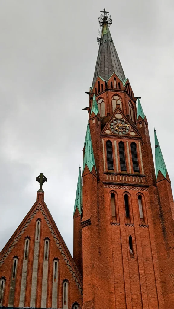 Backsteinturm der Stephanuskirche mit Uhr und grünen Ecktürmchen an der Prinzenallee in Gesundbrunnen