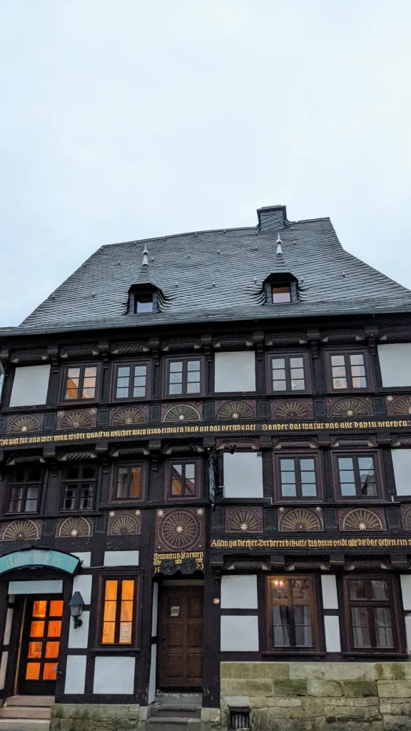 Dunkles Fachwerkhaus mit Schieferdach und verzierten Brüstungsbändern