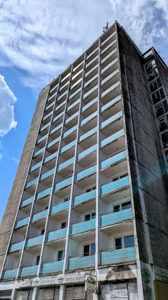 Leerstehendes Hochhaus an der Friedrich-Schiller-Straße in Guben mit hellblauen Balkonbrüstungen und verrammeltem Erdgeschoss