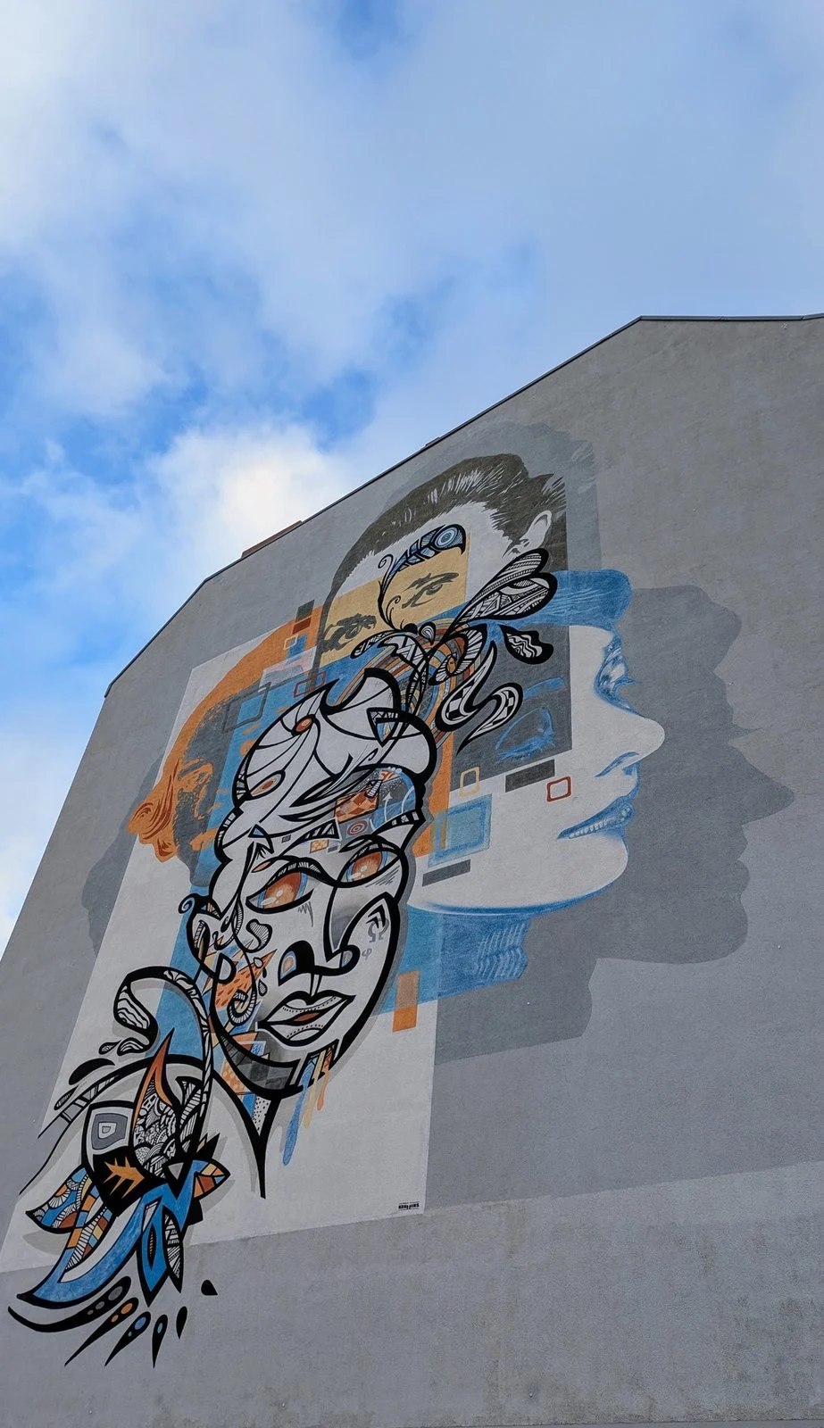 Großes farbiges Wandbild mit Gesichtern und Ornamenten an einer Brandwand, aufgenommen auf der Tour durch Halensee