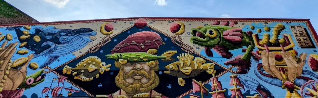Wandbild Störtebeker von DXTR und Rookie am Kanalplatz 5 in Hamburg-Harburg: bärtiger Seeräuber mit Hut zwischen Pixelfischen