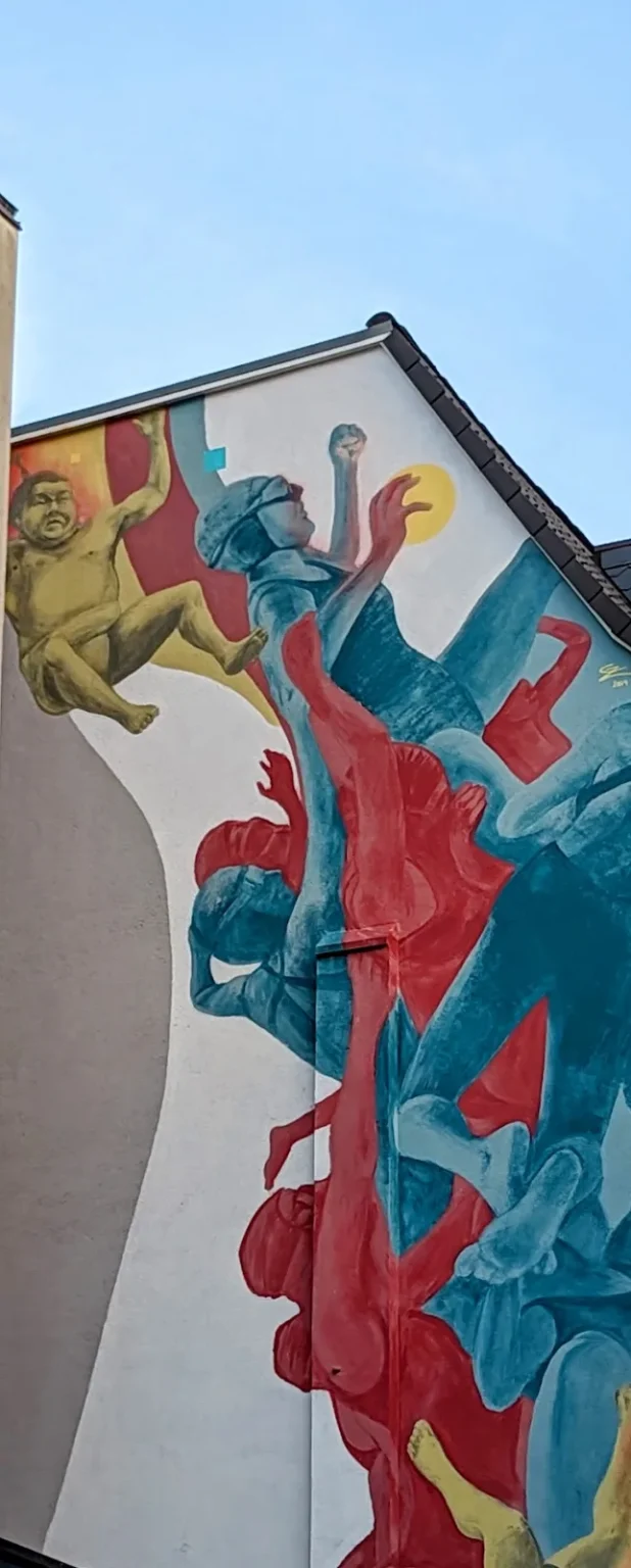 Wandbild Upside down von Guido Zimmermann an der Lüneburger Straße 12 in Hamburg-Harburg: ringende Figuren in Rot, Blau und Türkis