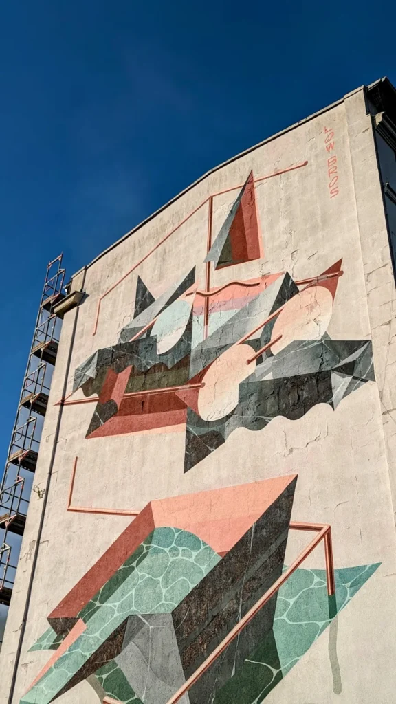 Wandbild Home Port der Low Bros an der Harburger Schloßstraße: geometrische Formen in Rosa, Grün und Schwarz auf heller Giebelwand