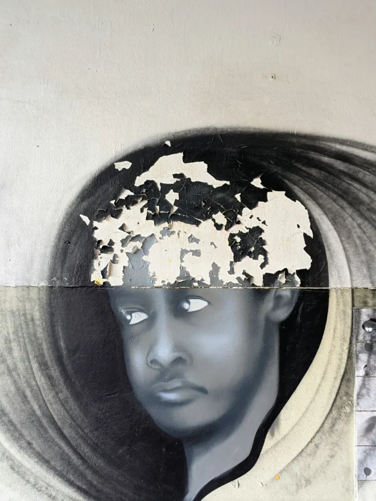Gemaltes Gesicht an einer Wand mit abblätterndem Putz im Heeresbekleidungshauptamt Bernau