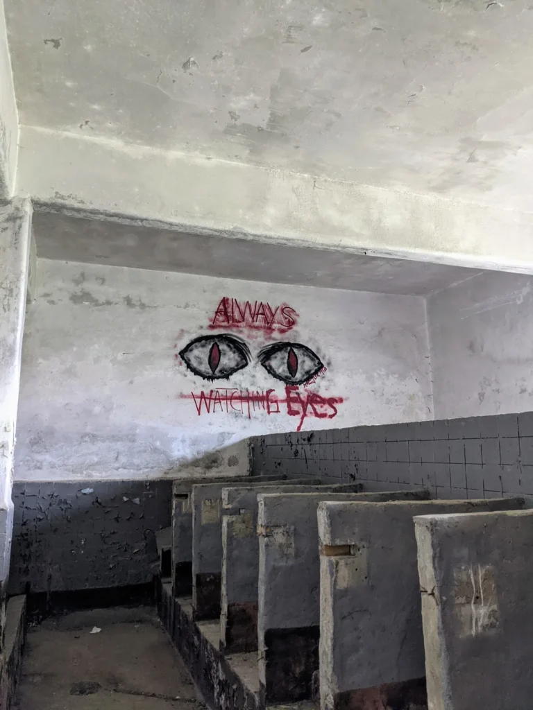 Raum mit Augen an den Wänden und dem Schriftzug „Always watching“ im Heeresbekleidungshauptamt Bernau