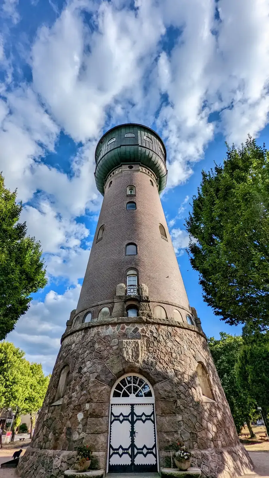 Wasserturm in Heide mit Natursteinsockel, Backsteinschaft und grüner Haube
