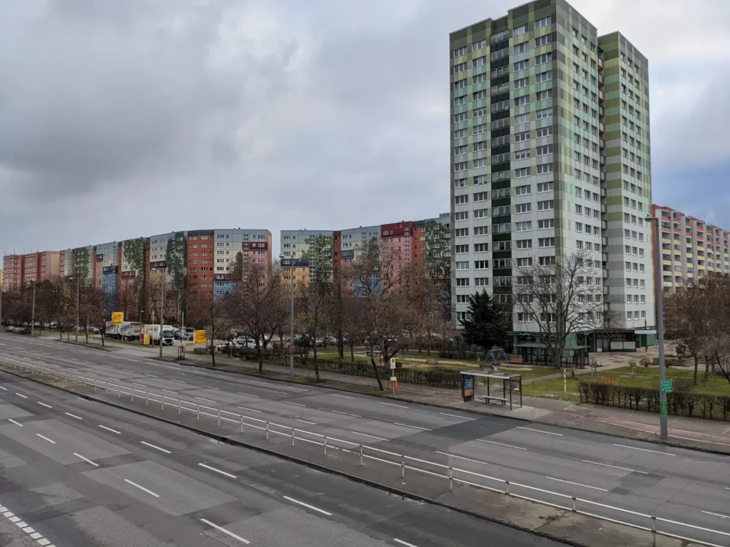 Blick von der Fußgängerbrücke auf die Bundesstraße Alt-Friedrichsfelde in Berlin mit Hochhaus und Plattenbauten