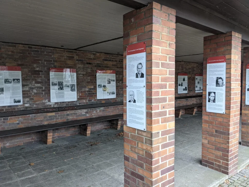 Überdachter Wartebereich mit Ausstellungstafeln am Eingang des Zentralfriedhofs Friedrichsfelde an der Gudrunstraße