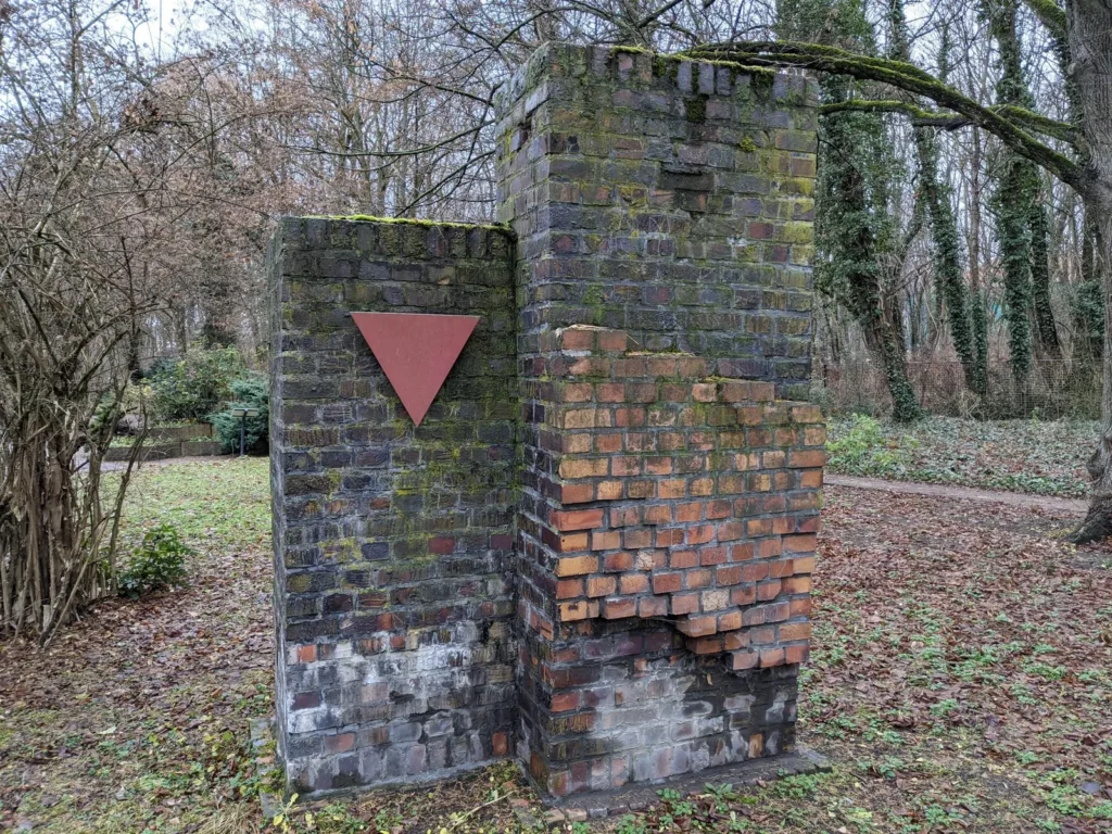Klinkerpfeiler mit rotem Winkel am Ehrenhain für die Verfolgten des Naziregimes auf dem Zentralfriedhof Friedrichsfelde