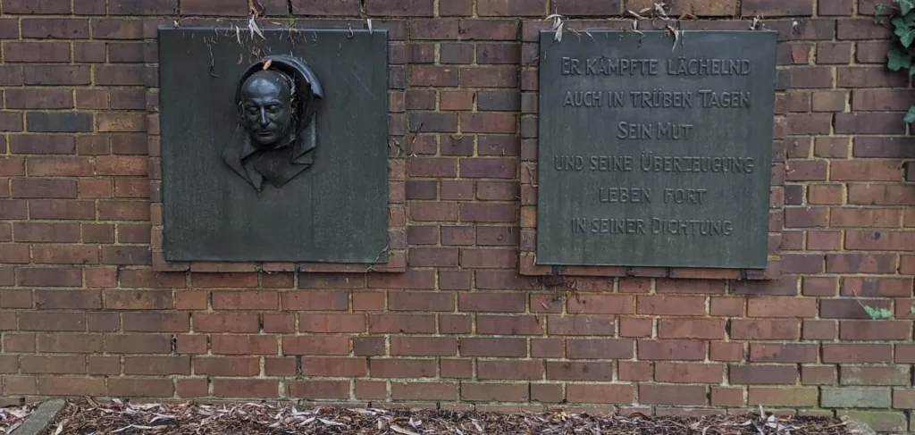 Grabplatte mit Porträtrelief und Inschrift an der Ringmauer der Gedenkstätte der Sozialisten auf dem Zentralfriedhof Friedrichsfelde