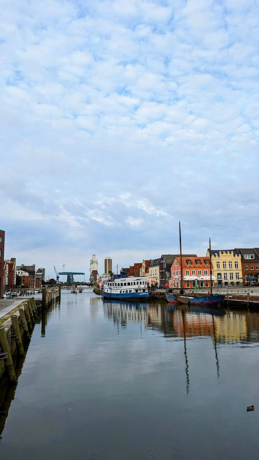 Binnenhafen in Husum mit Schiffen und bunten Giebelhäusern am Kai