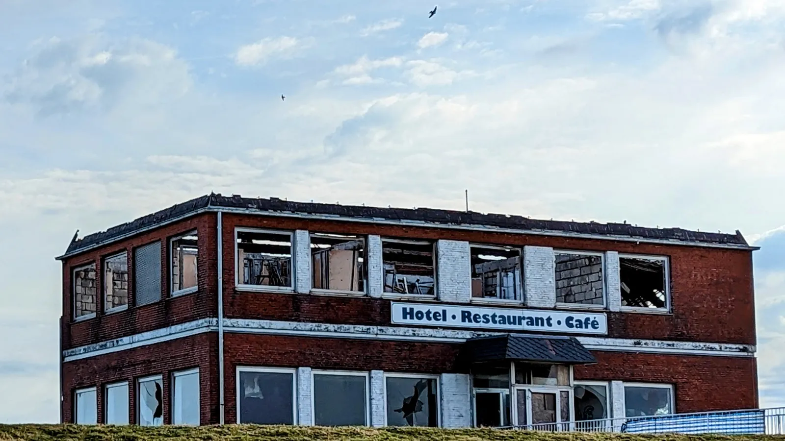 Ausgebrannte Ruine des Nordseehotels am Dockkoog in Husum mit Backsteinfassade, leeren Fensterhöhlen und dem Schriftzug Hotel, Restaurant, Café
