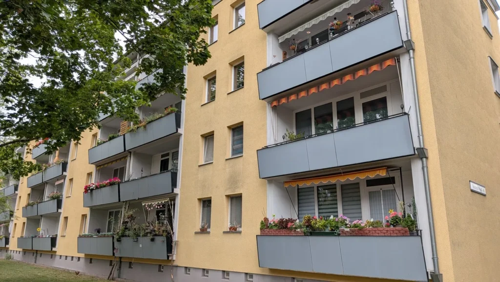 Gelb verputztes Wohnhaus mit Balkonen an der Balatonstraße in Berlin-Friedrichsfelde