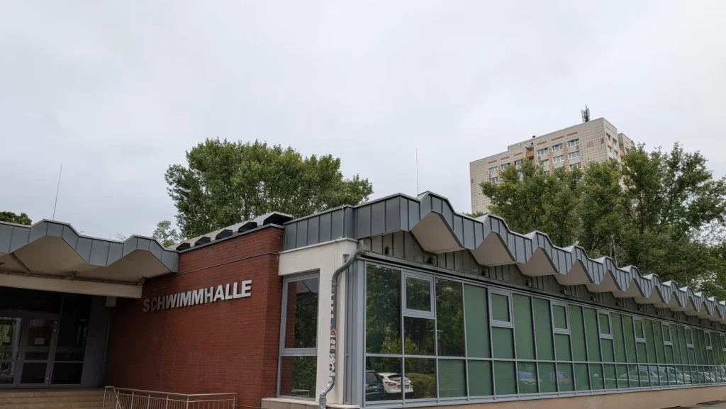 Glasfront der Schwimmhalle an der Sewanstraße in Berlin-Friedrichsfelde mit wellenförmiger Dachkante