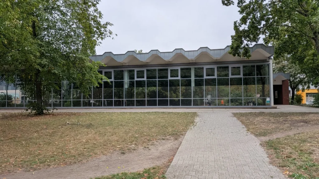 Schwimmhalle an der Sewanstraße in Berlin-Friedrichsfelde mit wellenförmigem Dach und Glasfront