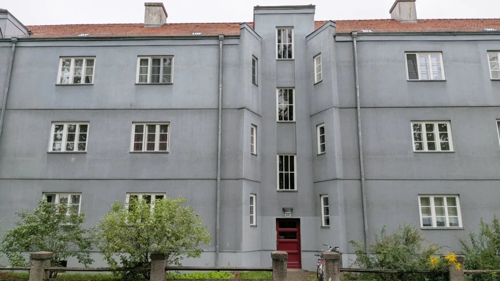 Verputzte Wohnhäuser der Splanemann-Siedlung in Berlin-Friedrichsfelde mit roter Haustür und grauem Anstrich