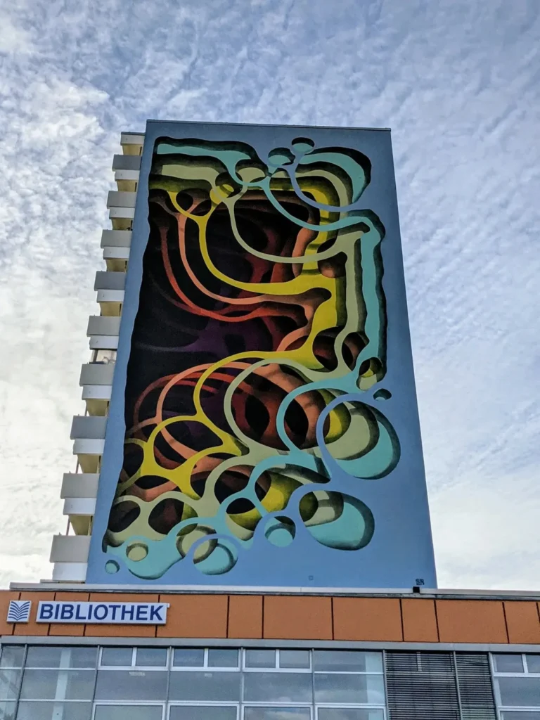 Wandbild Tropfen und Ringe des Künstlers 1010 an der Erich-Kurz-Straße in Berlin-Friedrichsfelde über der Bibliothek