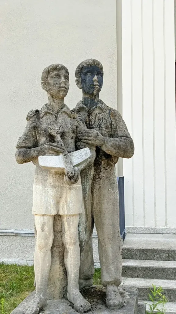 Steinplastik zweier Jugendlicher am Eingang des früheren Kinderheims an der Südostallee in Johannisthal