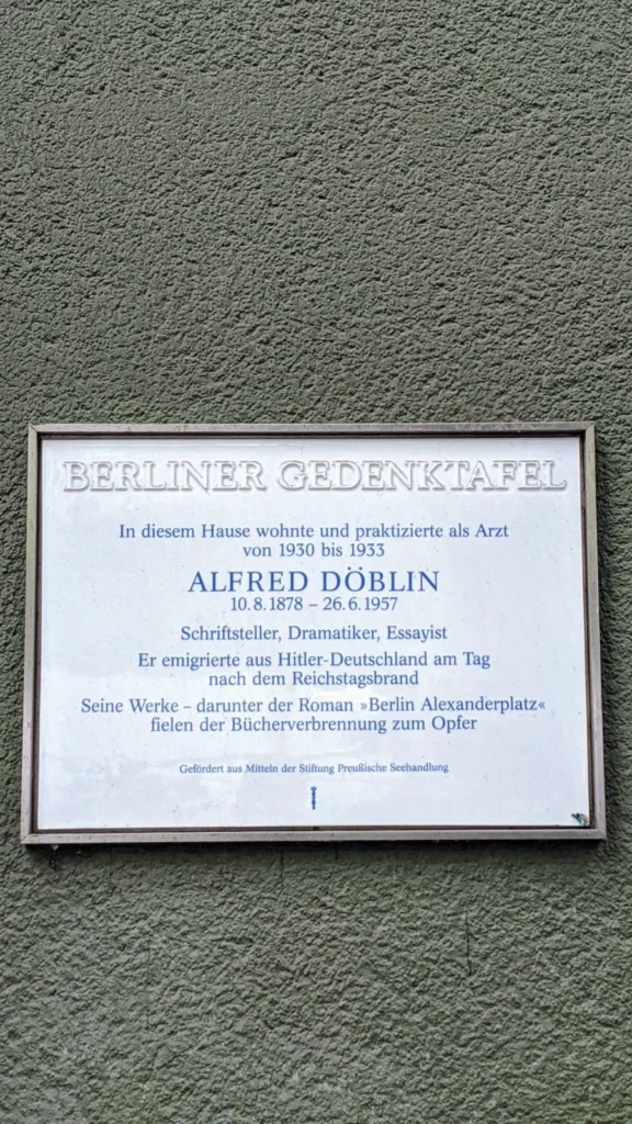 Berliner Gedenktafel für den Schriftsteller und Arzt Alfred Döblin an einer graugrünen Rauputzfassade