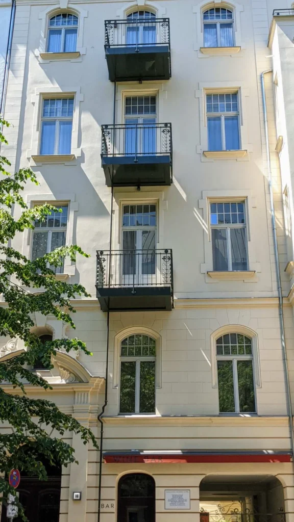 Gründerzeithaus Meinekestraße 10 in Charlottenburg mit Weinbar im Erdgeschoss und der Gedenktafel neben dem Tor