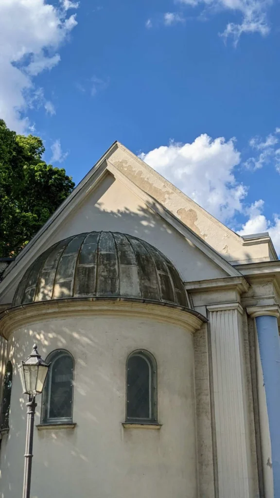 Halbrunder Anbau mit patinierter Metallhalbkuppel und Rundbogenfenstern am erhaltenen Seitenflügel der Synagoge Fraenkelufer