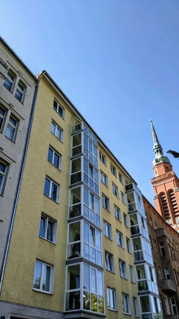 Wohnhaus aus den 1950er Jahren an der Schönhauser Allee 162, Standort des Auerbachschen Waisenhauses, rechts der Turm der Segenskirche