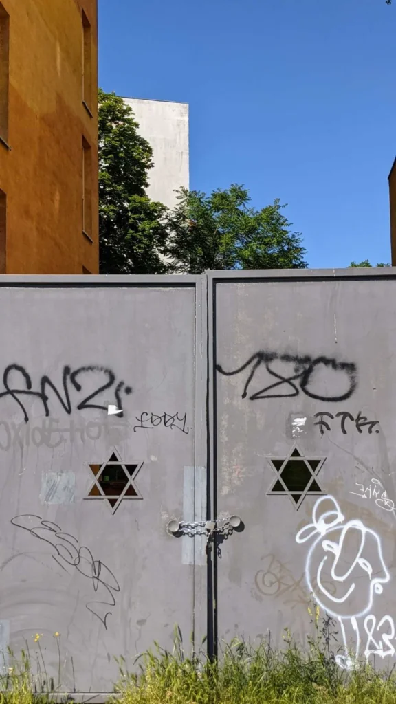 Graues Stahltor mit zwei ausgeschnittenen Davidsternen am Judengang am Senefelderplatz, mit Kette verschlossen