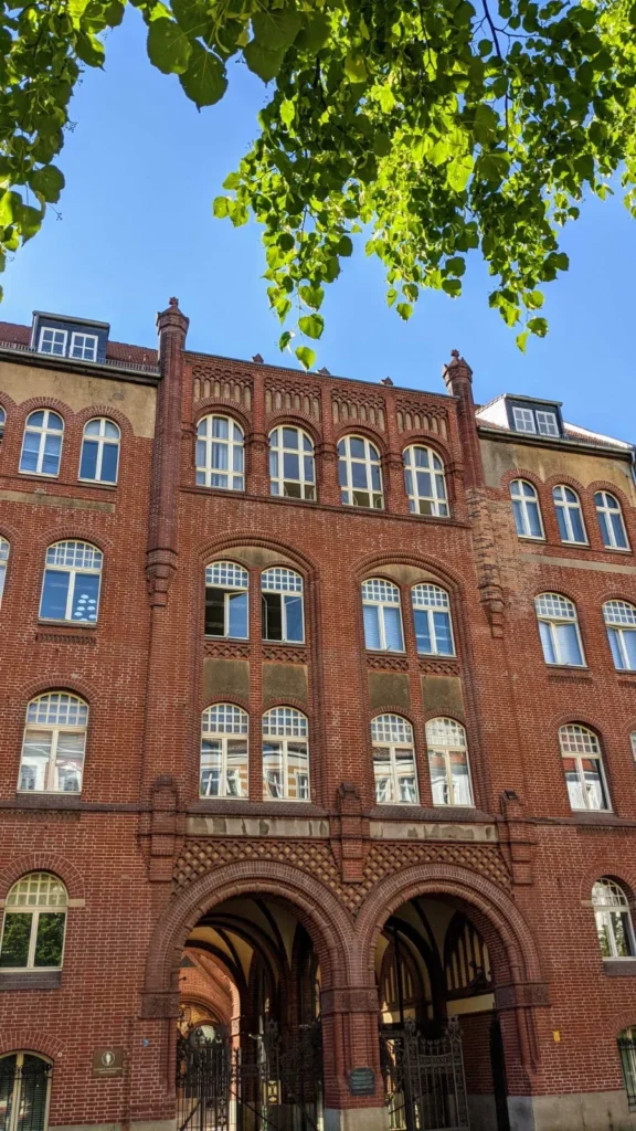Vorderhaus der Synagoge Rykestraße 53 aus rotem Backstein mit Doppelbogen-Durchfahrt und Davidsternen in den Torgittern