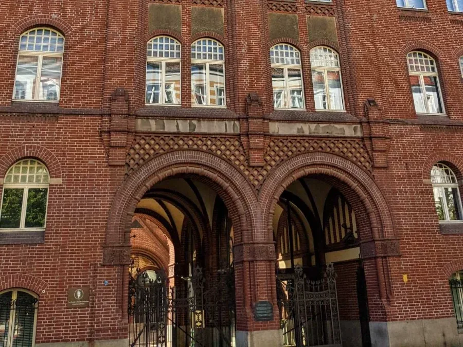 Vorderhaus der Synagoge Rykestraße 53 aus rotem Backstein mit Doppelbogen-Durchfahrt und Davidsternen in den Torgittern