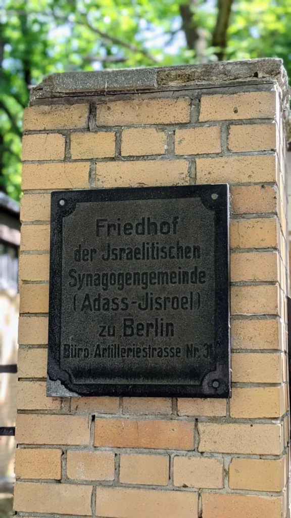 Gusseiserne Tafel am gelben Klinkerpfeiler des Tors zum Friedhof der Adass Jisroel in Weißensee