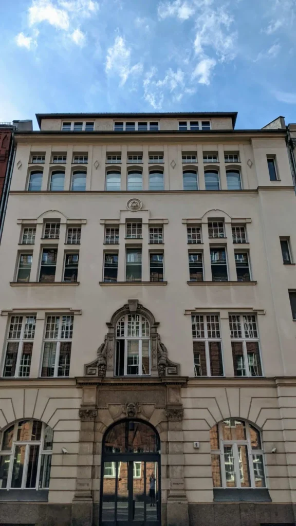 Hell verputzte Fassade Tucholskystraße 9 mit Davidstern-Medaillon, Rundbogenportal mit Löwenkopf und Hausnummer