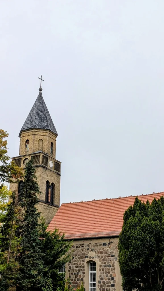 Feldsteinwand der Dorfkirche Karow mit Rundbogenfenster, links der Turm