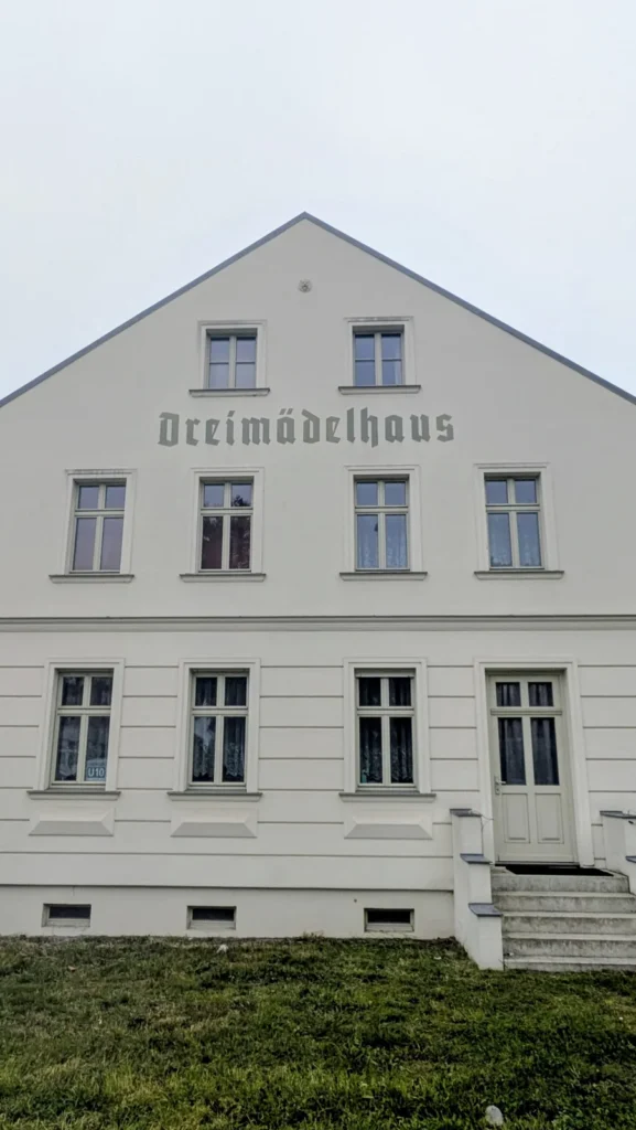 Helles Giebelhaus mit dem Schriftzug Dreimädelhaus in Alt-Karow