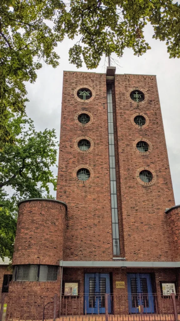 Backsteinkirche St. Martinius in Kaulsdorf mit Schlitzfenster, runden Fenstern und zwei blauen Türen