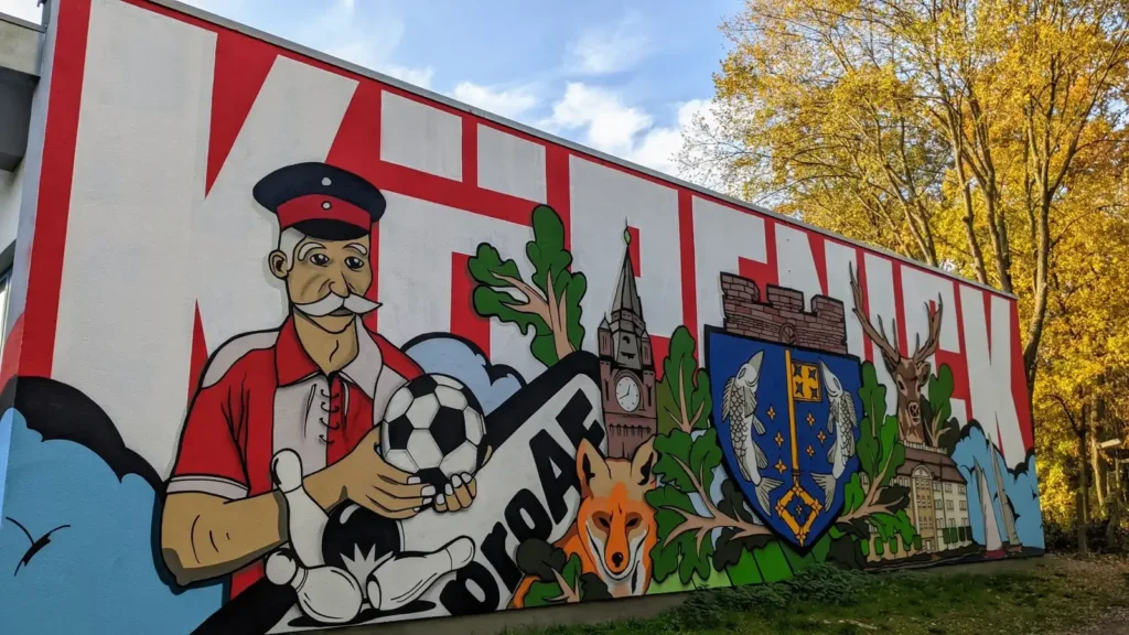 Großes Wandbild des 1. FC Union an einer Hauswand in Köpenick, mit dem Hauptmann von Köpenick als Figur