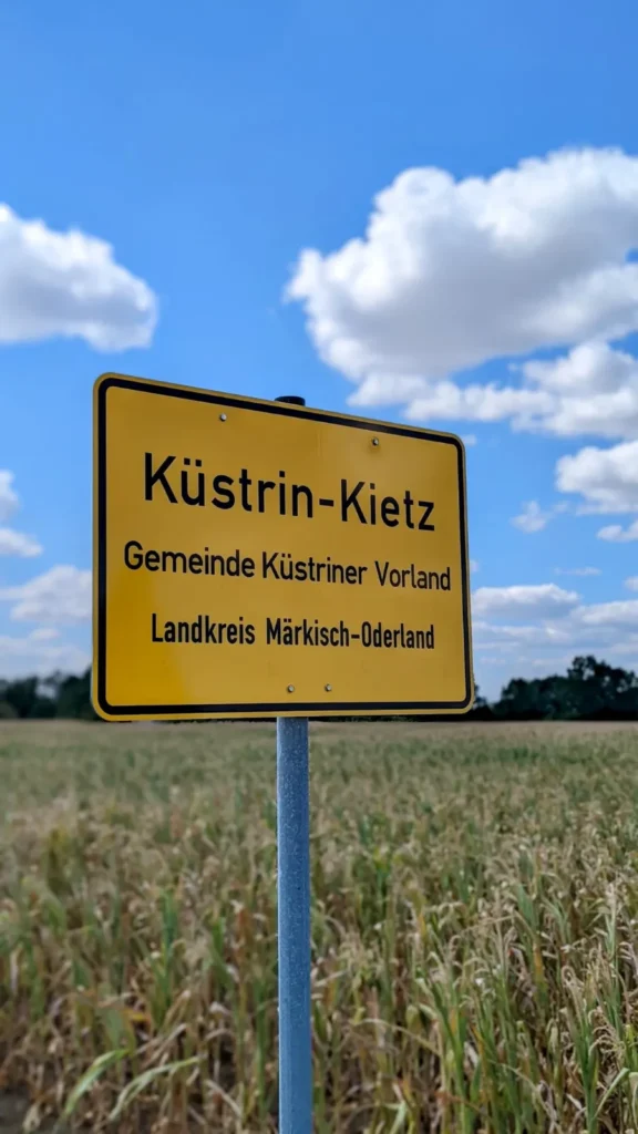 Gelbes Ortsschild Küstrin-Kietz, Gemeinde Küstriner Vorland, Landkreis Märkisch-Oderland, vor einem Feld