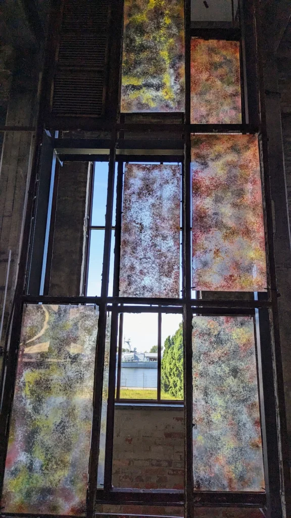 Hohes Fenster mit farbig gemusterten Scheiben im Kraftwerk