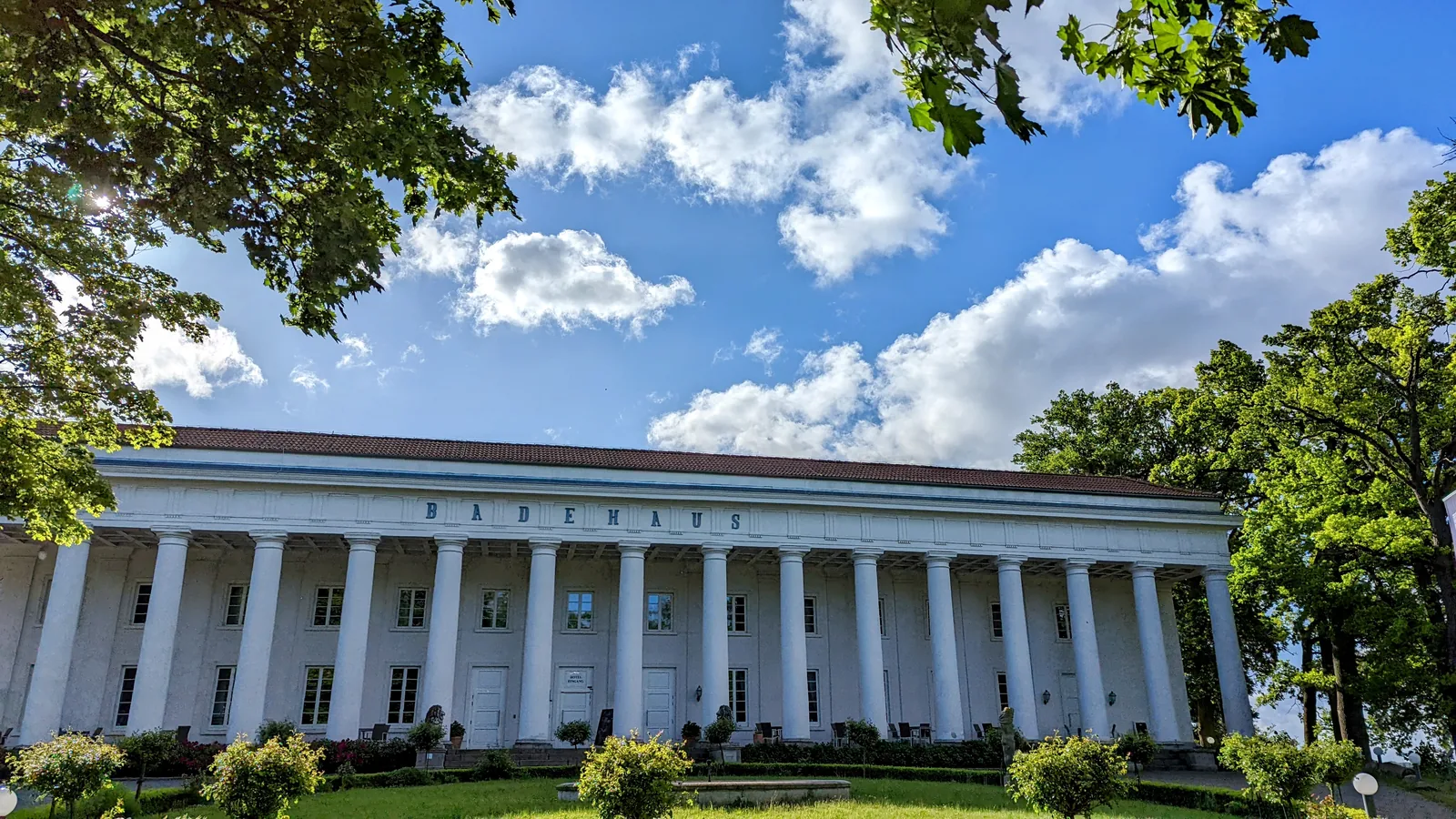 Weiße Säulenhalle des Badehauses Goor bei Lauterbach mit Garten davor