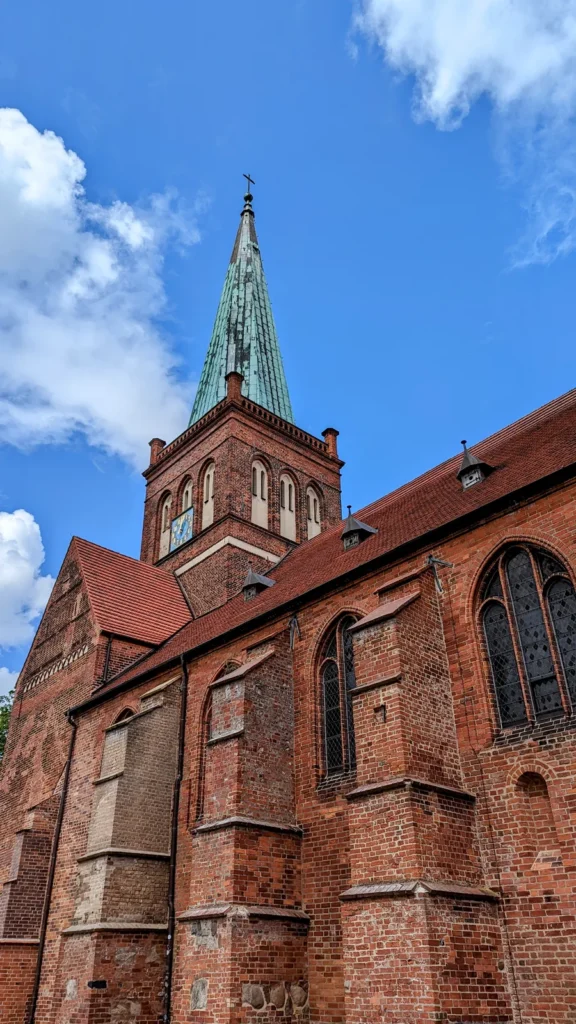 Backsteinturm der Kirche St. Marien in Bergen auf Rügen mit grüner Turmspitze
