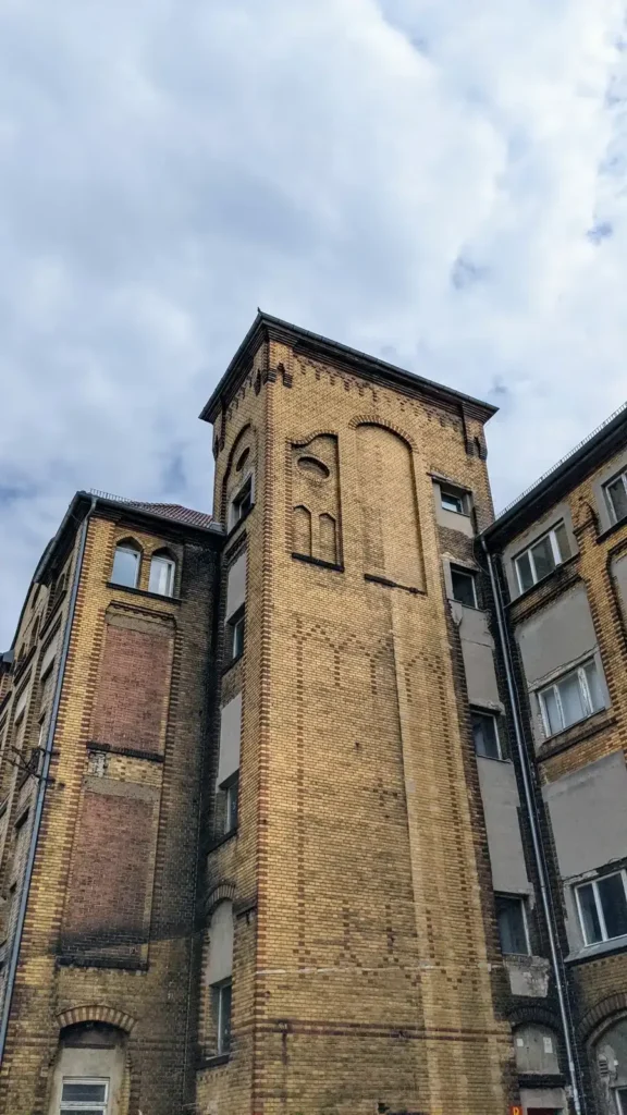 Alter gelber Backsteinbau mit Turm im Gewerbegebiet an der Herzbergstraße in Lichtenberg
