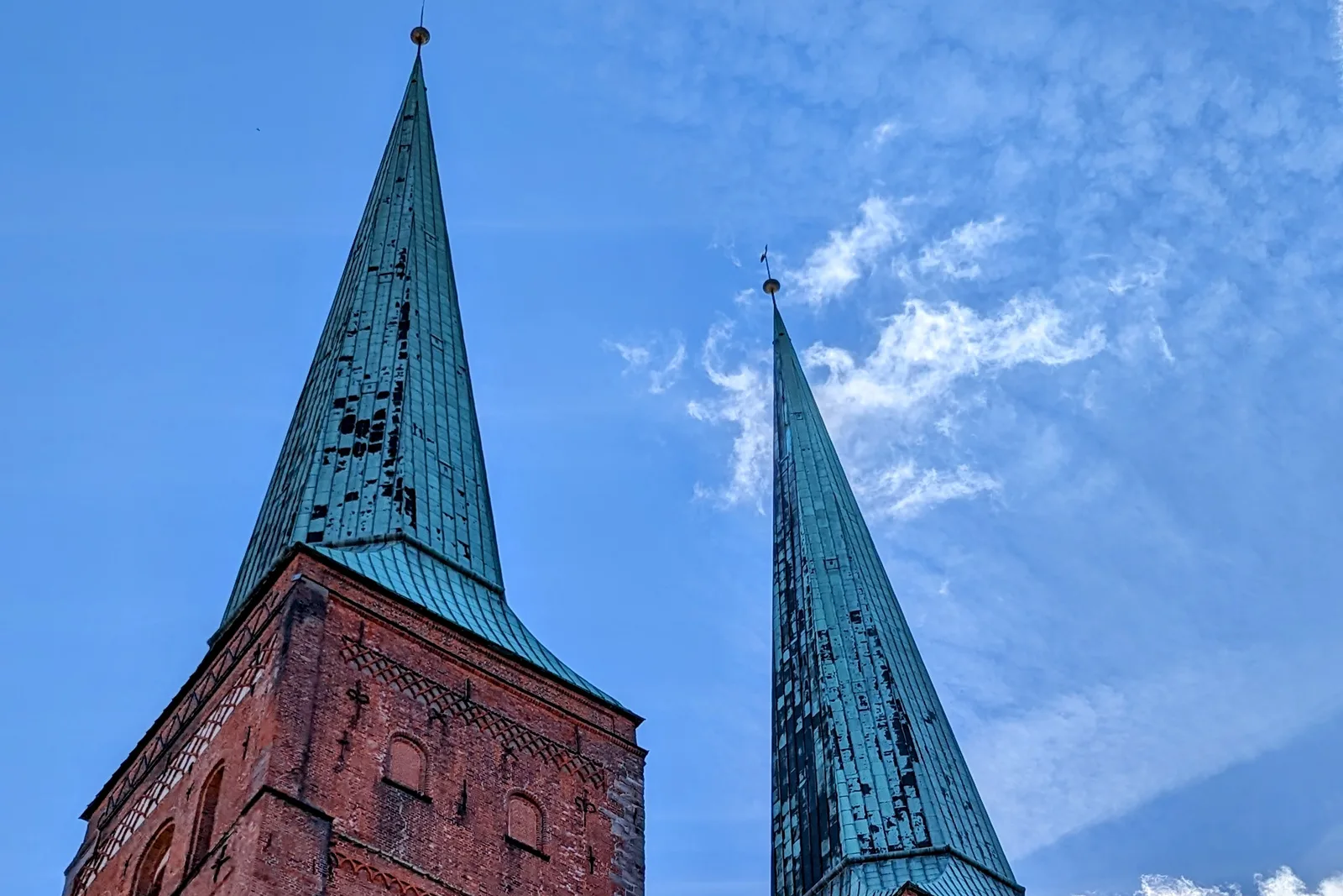 Die beiden Kupferspitzen der Türme des Lübecker Doms vor blauem Himmel