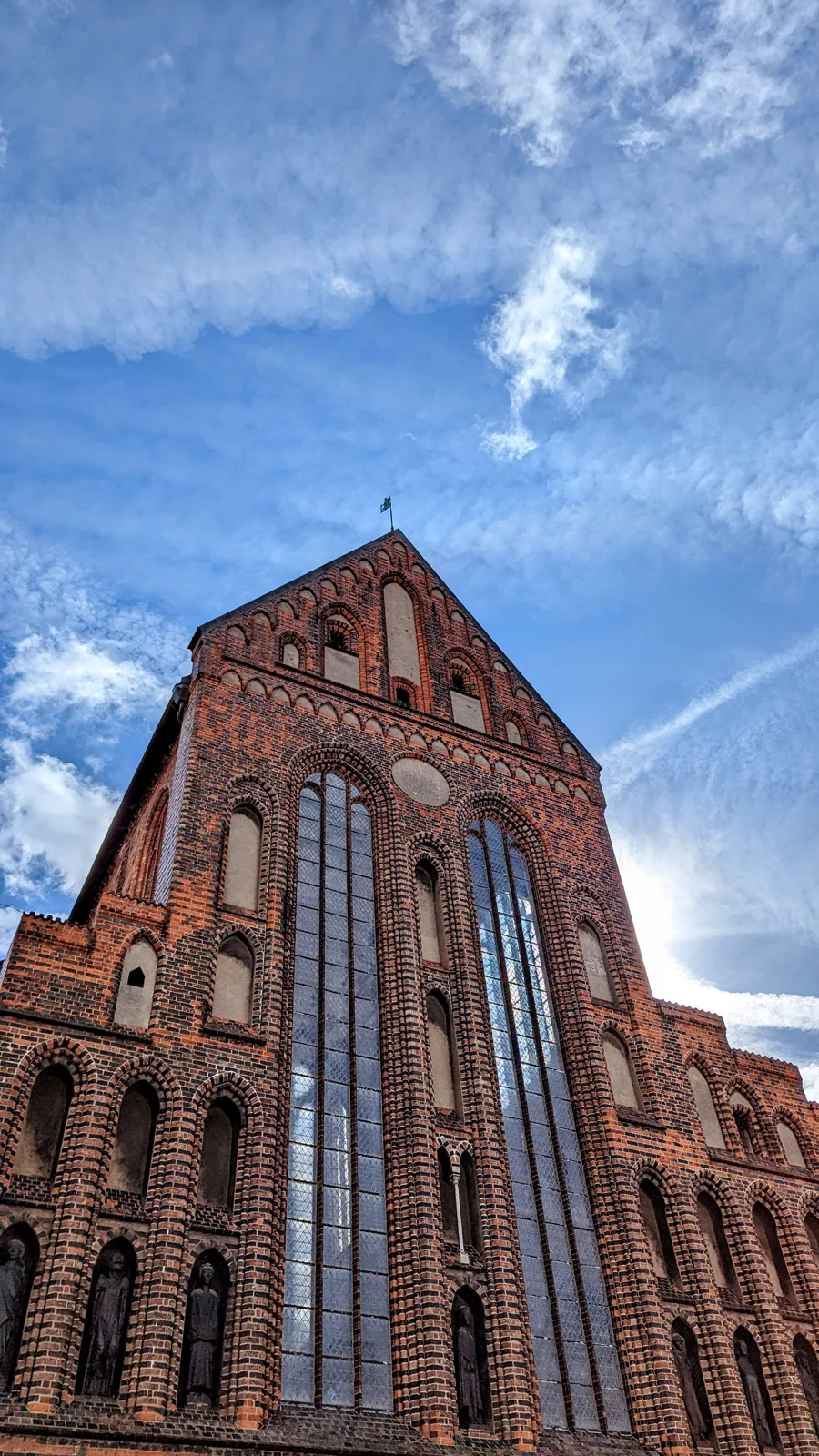 Backsteinfassade der Katharinenkirche in Lübeck mit hohen Fenstern und Figurennischen