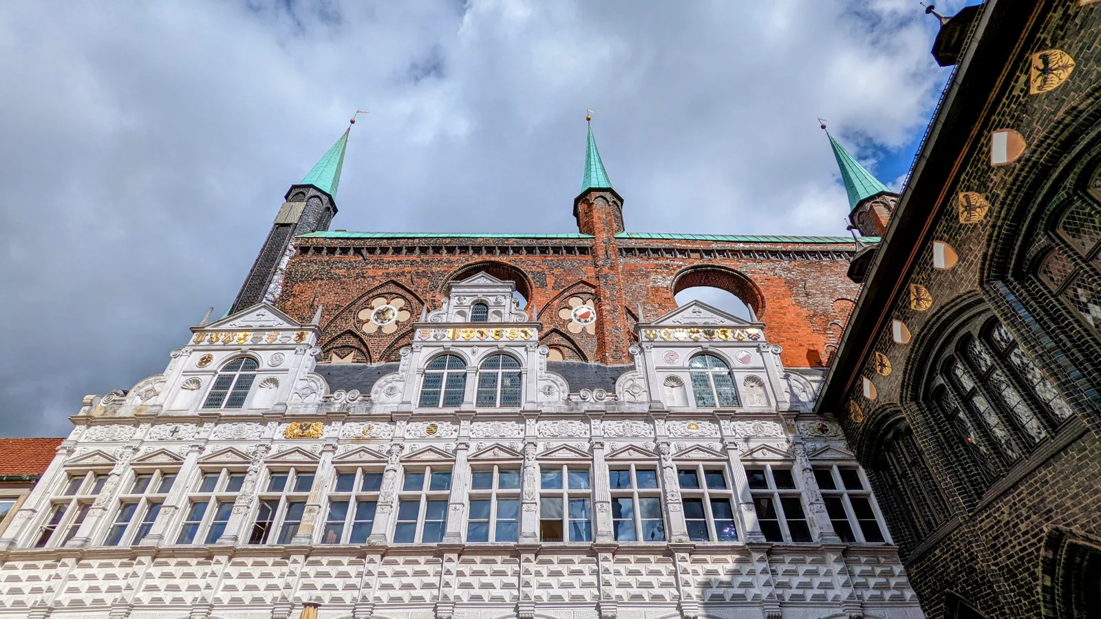 Weiße Schauwand des Lübecker Rathauses mit drei Türmchen